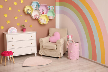 Cute child's room interior with beautiful rainbow painted on wall
