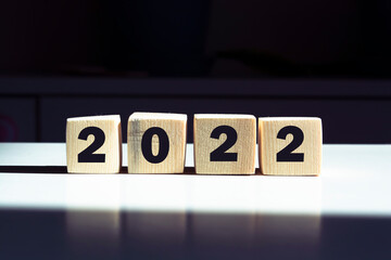 The concept of global business planning, wooden cube with word blocks in 2022 on the background of...