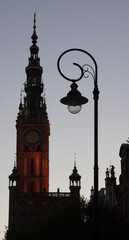Sunset and classic street lantern in front of tower hall clock tower Gdansk, Poland