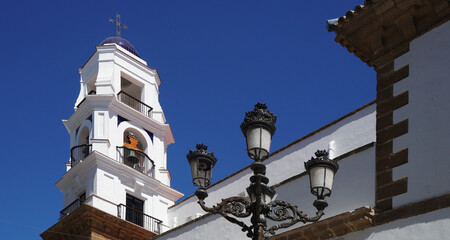 A classic street lantern in front of a traditional church under the clear blue sky, Cadiz, Spain