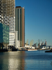 A collection of modern residential skyscrapers, part of the docklands regeneration, beside the Thames and ahead of the Millennium Dome.