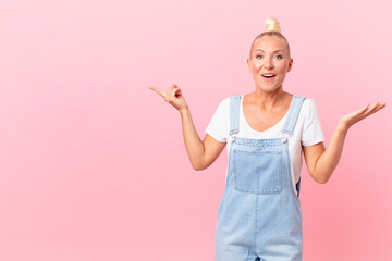 pretty blond woman feeling happy and astonished at something unbelievable