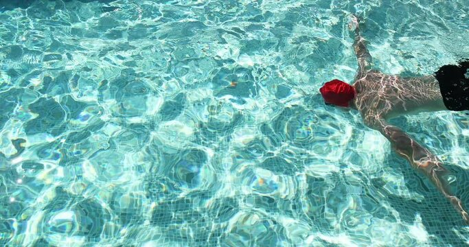 Man swimming under water in swimming pool