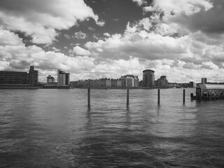 A slow shutter, infra-red filtered, monochrome view across the Thames from Canada Water to new residential buildings on the other side of the river.