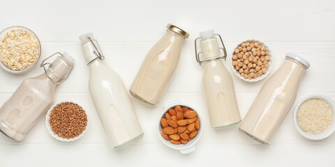Obraz na płótnie Canvas Dairy free alternative plant and nut milk in glass bottles on a gray background. Healthy vegan food concept. Top view