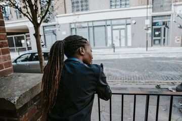 Fit woman waiting by a fence