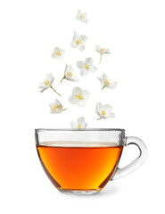 Beautiful jasmine flowers falling into cup of hot freshly brewed tea on white background