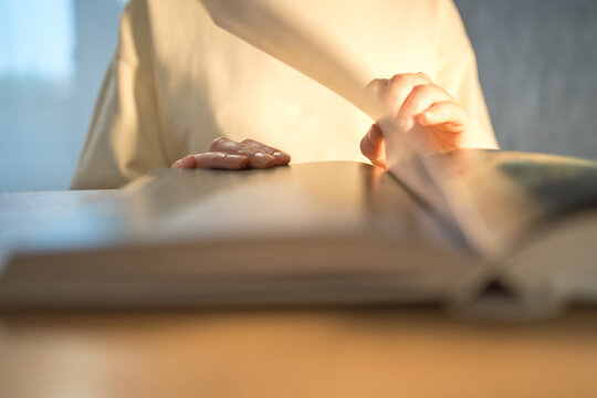 Reading a book. A person flips paper pages close-up