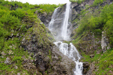 Obraz premium Polikarya Waterfall, located on the slope of Mount Aibga, in Krasnaya Polyana, Sochi. The height of the waterfall is 70 meters