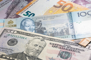 Obraz na płótnie Canvas Close up to 100 Gourde of the Republic of Haiti between 50 US Dollar and 50 Euro banknotes. one hundred Gourde banknotes of the Caribbean country Haiti. Money of the US and Europe with Haiti banknote