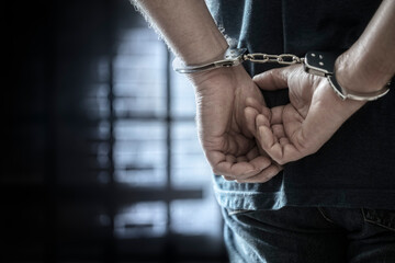 Criminal wearing handcuffs in prison - obrazy, fototapety, plakaty