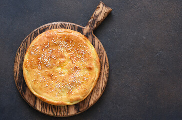 Khachapuri with suluguni cheese and cheese on a wooden board. 