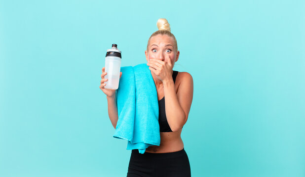 pretty blond woman covering mouth with hands with a shocked. fitness concept