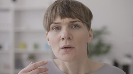 Upset female looking at wrinkles on face, unhappy with mirror reflection, aging
