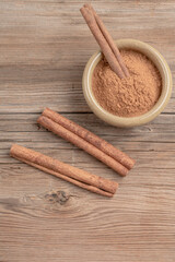 dried cinnamon sticks and powder on wooden table with copy space