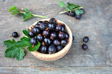 Porzeczkoagrest w drewnianej misce na tle desek