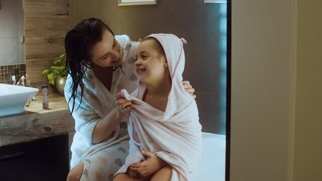 <om wipes her hair with a towel little daughter after bathing