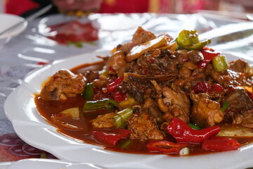 Xinjiang big plate chicken. Spicy chicken meat with colorful peppers. Traditional food in Xinjiang...