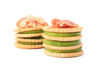 Delicious crackers with cucumber and prosciutto on white background