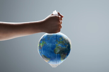Hand holding planet earth in a plastic