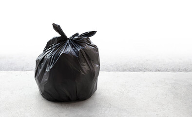 Black garbage bag, trash recycle plastic bag on white concrete floor on street. copy space