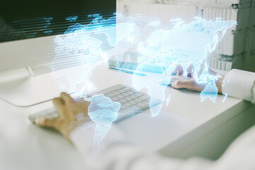 Abstract creative digital world map and hands typing on laptop on background, globalization...