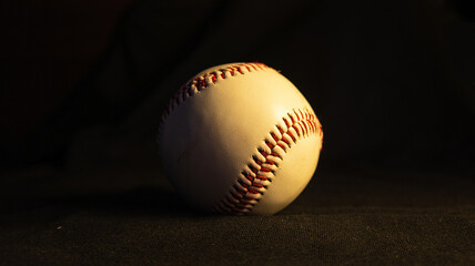 A baseball ball on a dark background.