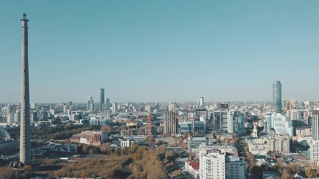 Unfinished TV tower and the central district of the Ekaterinburg city, Russia. Video. Aerial view of a cityscape in the summertime on blue sky background.