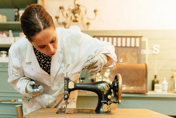 young Hispanic woman working in her carpentry shop. person restoring and painting old sewing...