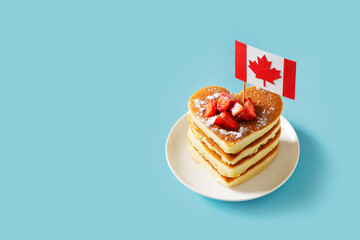 Stack of pancakes with strawberreis and canadian flag on canada day celebration