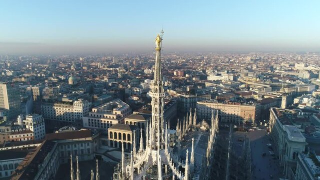 Aerial drone footage view of sunrise of famous statue on cathedral Duomo in Milan Italy  // no video editing