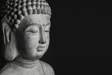 Beautiful stone Buddha sculpture on black background, closeup. Space for text