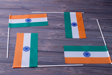 Composition of four indian flags on grey wooden background.
