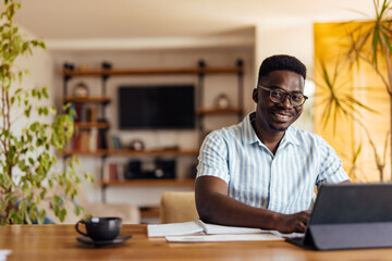 Adult black man, posing for the camera in his home office.