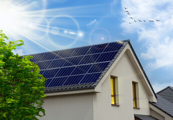 Solar panel on a roof reflecting the sun and the cloudless blue sky. Solar panels on the gable roof...