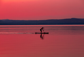 Fototapeta na wymiar a man on a raft in the evening on the lake