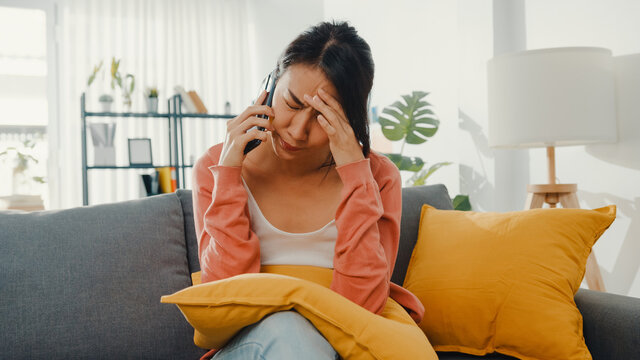 Young Lady Sitting On Sofa Talk With Friend And Get Bad News At Home. Long Distance Relationship, Bad Relationship, Work Problem, Broken Relationship, Keep Distance, Covid Quarantine Concept.