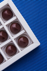 Vertical shot sweet brown chockolate candies in the box.
