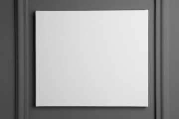 Blank canvas hanging on grey wall, space for text