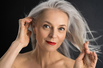 Adult senior woman touching her perfect grey hair