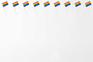 Obraz premium Lgtbi community rainbow flags pattern with hard shadow on white background. Pride day concept