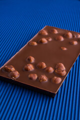 Vertical shot milk chocolate bar with whole hazelnuts.