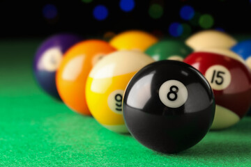 Many colorful billiard balls on green table, closeup. Space for text