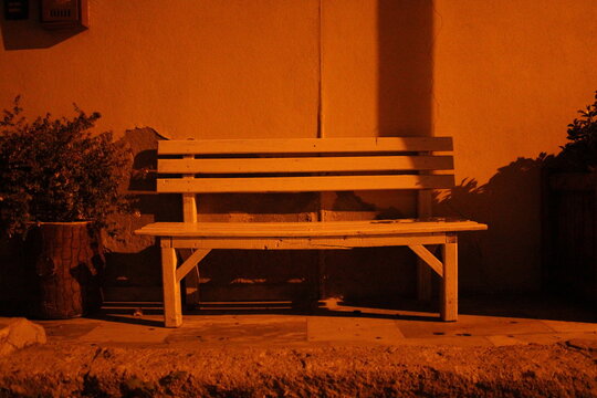 A white bench lid by the street lights
