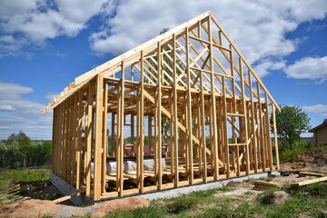 Wood frame residential building under construction.Building construction, wood framing structure at new property development site.new home currently under construction against blue sky.mortgage, loan.