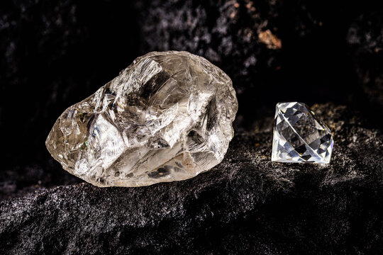 cut diamond with rough diamond gem on kimberlite rock, on isolated background, diamond business concept.