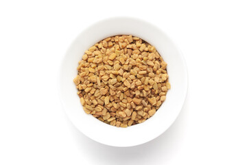 Macro close-up of Organic Fenugreek seed (Trigonella foenum-graecum )  on white background. Pile of Indian Aromatic Spice. Top view