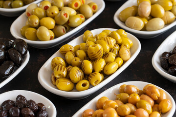Assortment of olives on the plate in bulk. Organic black olives, Olive varieties