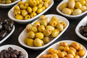 Assortment of olives on the plate in bulk. Organic black olives, Olive varieties
