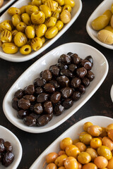 Assortment of olives on the plate in bulk. Organic black olives, Olive varieties